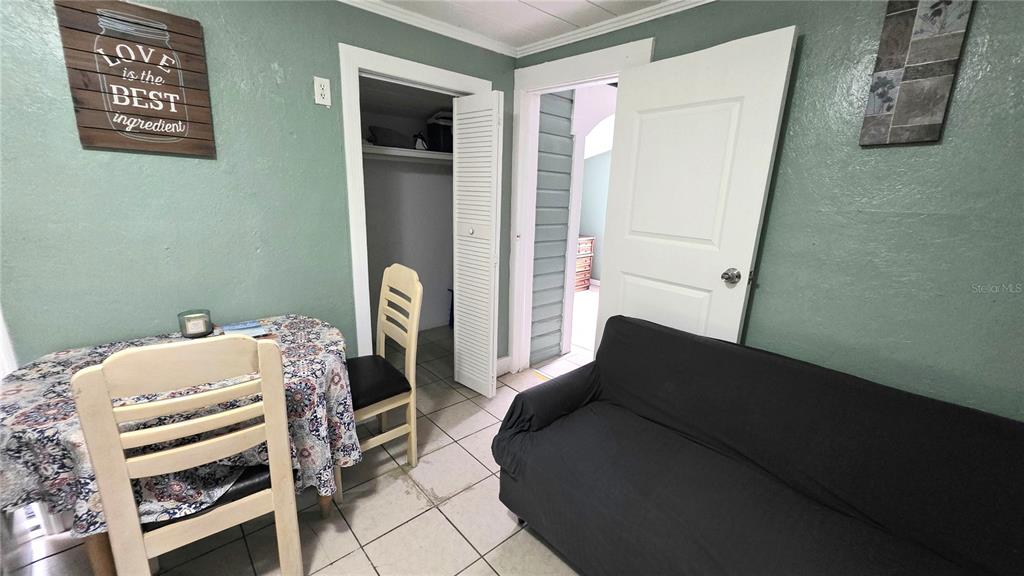 A room with tile flooring features a dining table, a sofa, and two doorways — 2031 4TH STREET, SARASOTA, FL