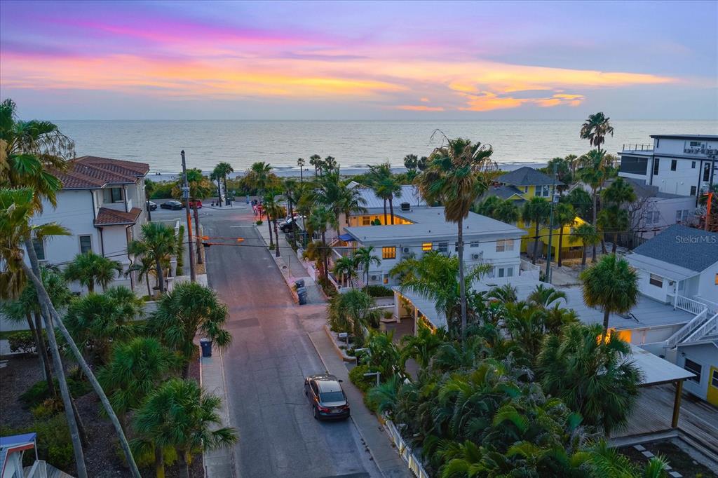 A single-story beach inn with a white fence, palm trees, and string lights at dusk — 109 14TH AVENUE, ST PETE BEACH, FL