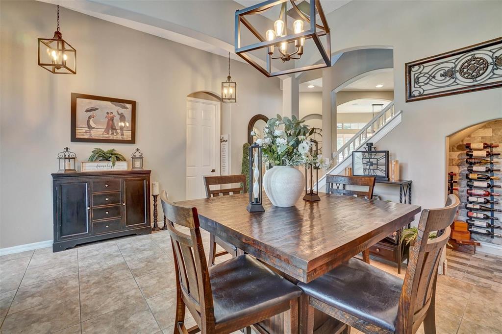 A dining room features a square wooden table, dark cabinetry, and a built-in wine rack — 324 TUDOR SPRING COURT, ORLANDO, FL
