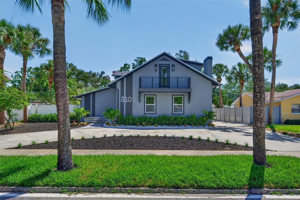 An aerial view of a house at dusk with a sunset over the water behind — 310 PARK STREET N, ST PETERSBURG, FL