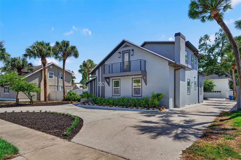 An aerial view shows a house with a pool surrounded by trees near a bay — 310 PARK STREET N, ST PETERSBURG, FL