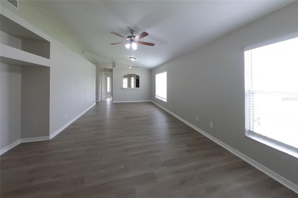 An entryway with wood-look tile flooring leads to a hallway and an adjacent room — 6705 CAMBRIDGE PARK DRIVE, APOLLO BEACH, FL
