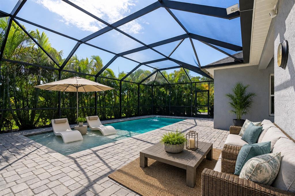 A screened-in patio features a swimming pool with lounge chairs and a wicker sofa set — 4727 CREEKRIDGE COURT, BRADENTON, FL