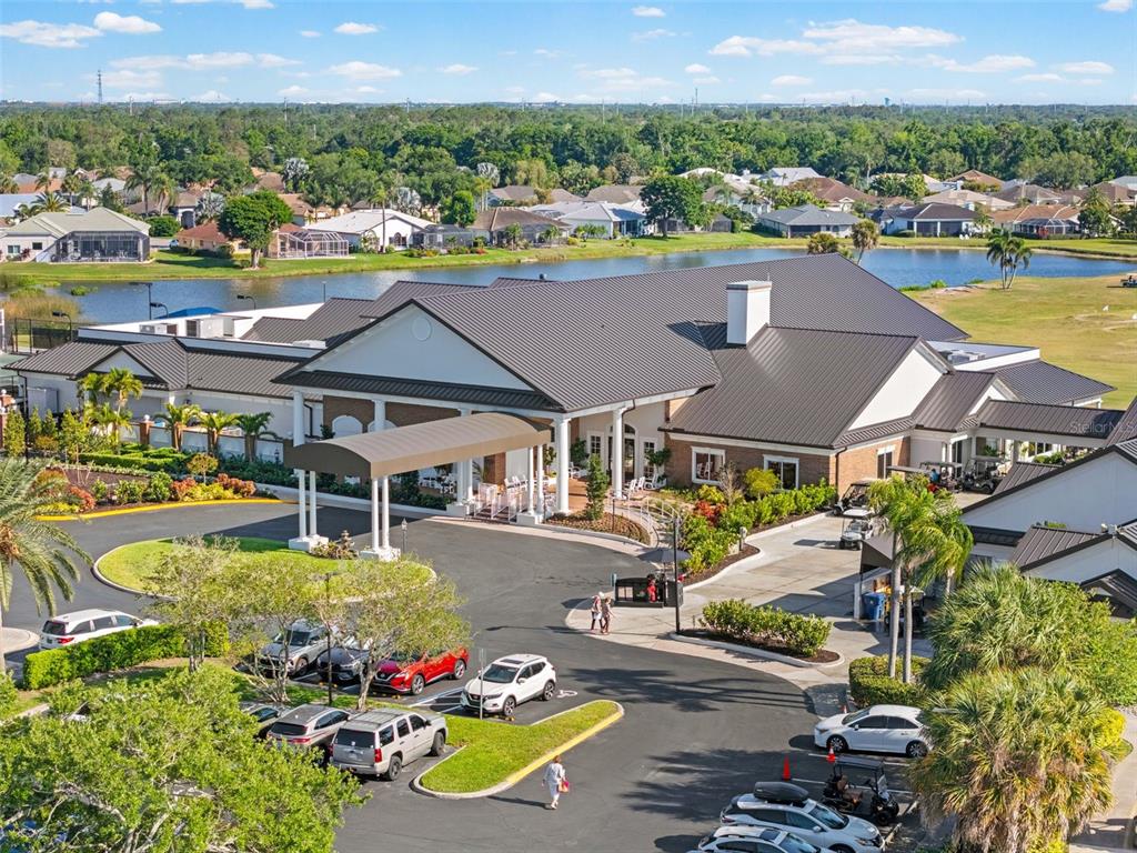 An aerial view of a large clubhouse building with a covered entrance and parking lot — 6503 STONE RIVER ROAD UNIT 204, BRADENTON, FL