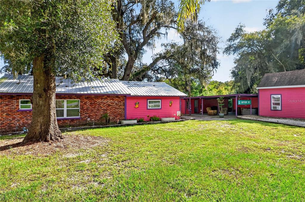 A bright pink house with purple trim, a white front door, and a paved patio — 11717 E SALMON DRIVE, FLORAL CITY, FL