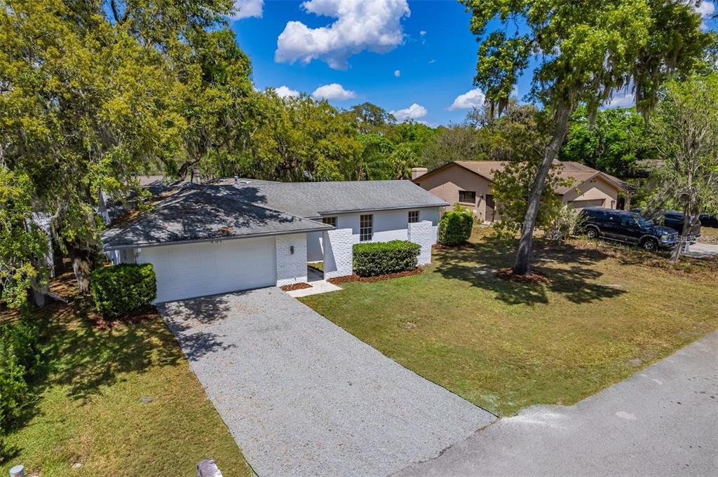 An aerial view of a single-story white brick house with a gravel driveway and trees — 437 ALPINE STREET, ALTAMONTE SPRINGS, FL