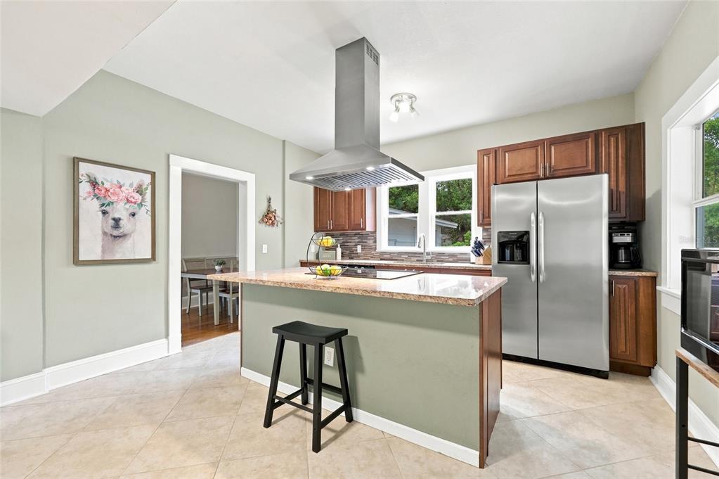 A dining room features hardwood floors, a wooden sideboard, a table with chairs, and wallpaper — 4114 E MICHIGAN STREET, ORLANDO, FL