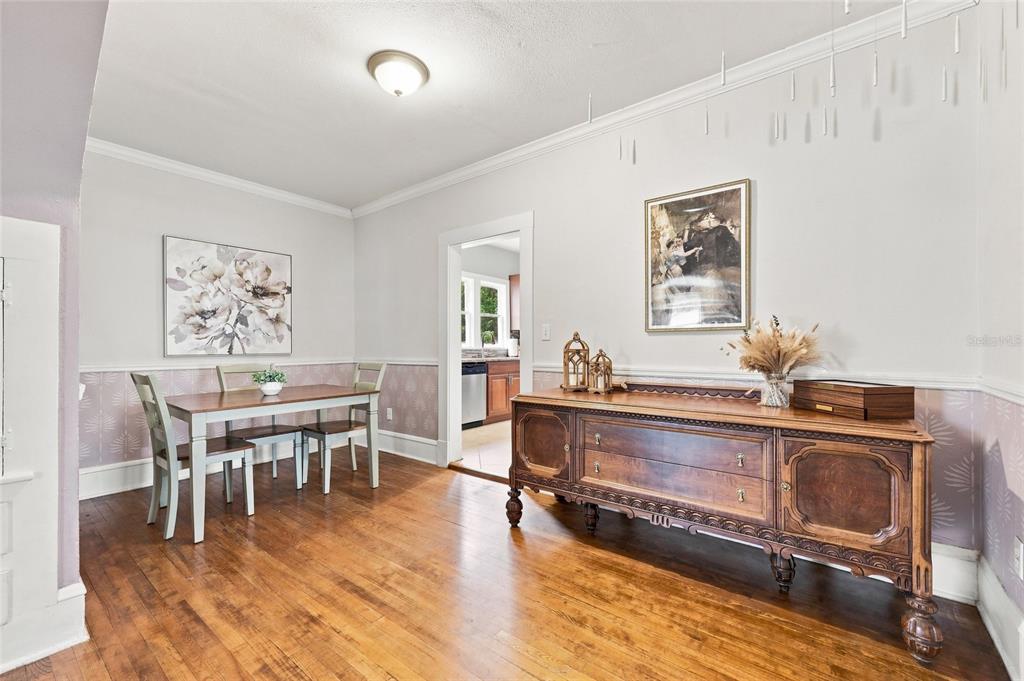 A living room features a grey sofa, a teal armchair, a television, and hardwood floors — 4114 E MICHIGAN STREET, ORLANDO, FL