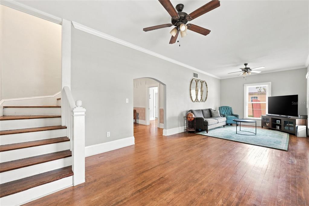 A covered front porch with a blue door, dark wood flooring, and white siding — 4114 E MICHIGAN STREET, ORLANDO, FL