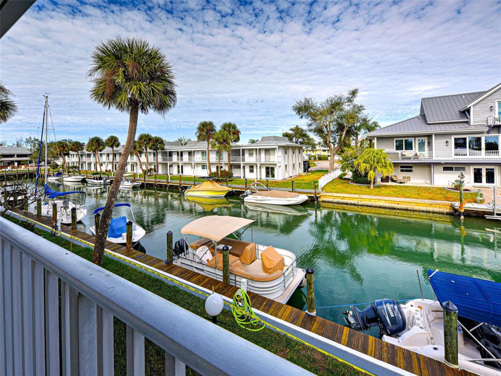 A view from a balcony overlooking a canal lined with boats and residential buildings — 902 GIBBS ROAD UNIT 285, VENICE, FL