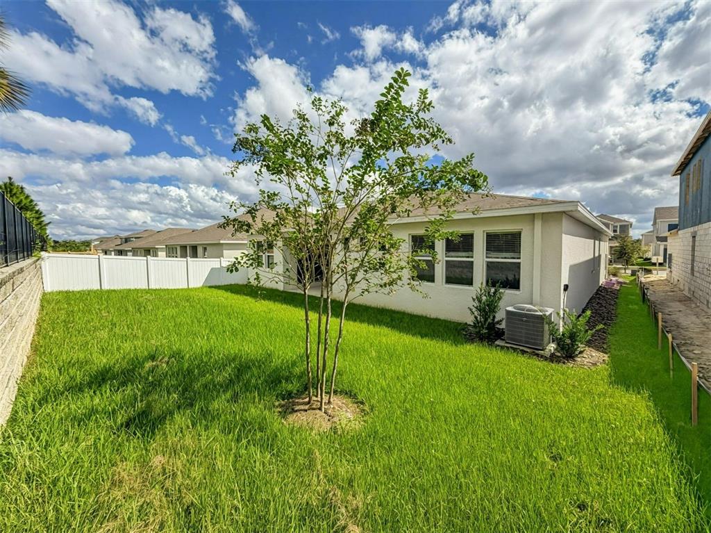 A dining room with light gray walls, tile flooring, a wooden table, and four chairs — 1801 RIDER RAIN LANE, APOPKA, FL