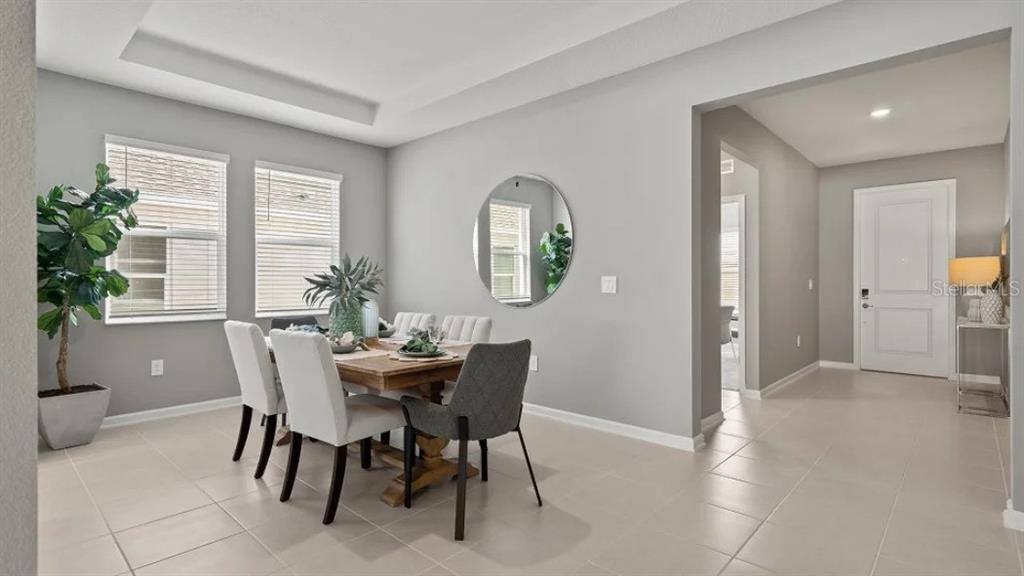 An open-concept living room features a white sectional sofa, a coffee table, and a kitchen — 1801 RIDER RAIN LANE, APOPKA, FL