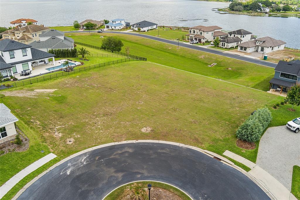 An aerial view shows a vacant residential lot situated in a cul-de-sac near a lake — 200 CALADONIA COURT, LAKE ALFRED, FL