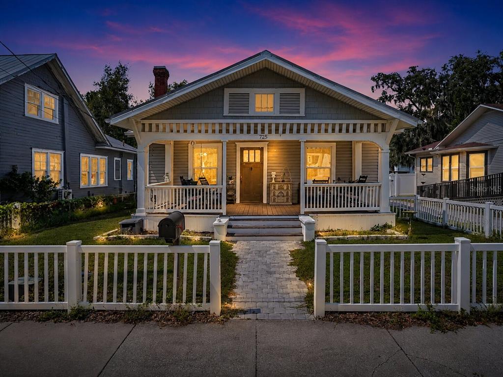 A light gray bungalow with a front porch, white picket fence, and a stone walkway — 725 MABBETTE STREET, KISSIMMEE, FL