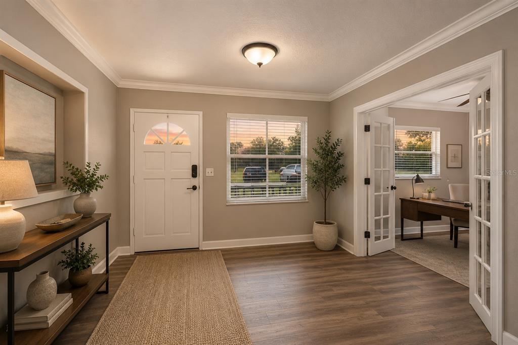 An entryway with wood-look flooring, a white front door, and French doors leading to an office — 1330 S SHORE DRIVE, ST CLOUD, FL