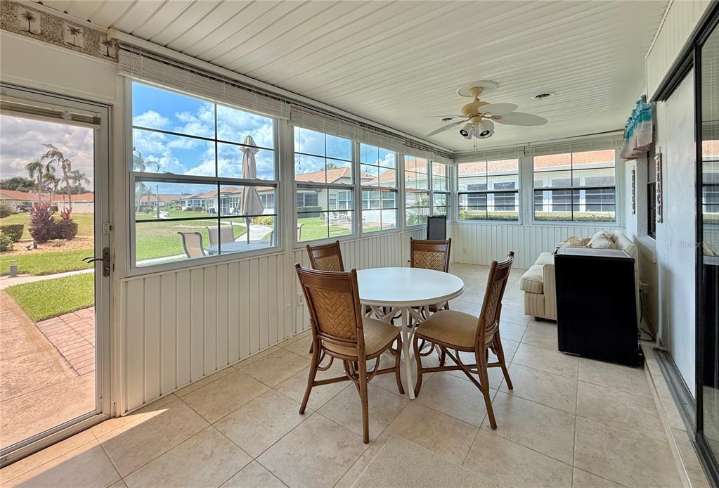 A sunroom features tile flooring, a dining set, a ceiling fan, and large windows — 4827 CADAGUA DRIVE, SEBRING, FL