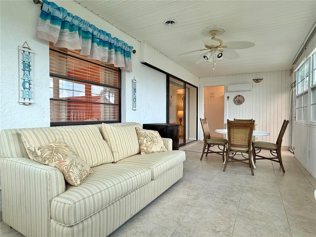 A sunroom features a striped sofa, a dining set, tile flooring, and a ceiling fan — 4827 CADAGUA DRIVE, SEBRING, FL