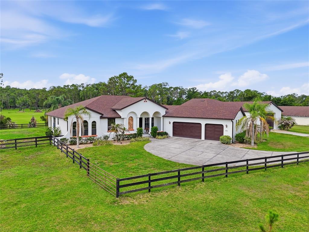 An aerial view of a single-story white house with a brown roof and attached garage — 4460 RUNWAY LANE, ST CLOUD, FL