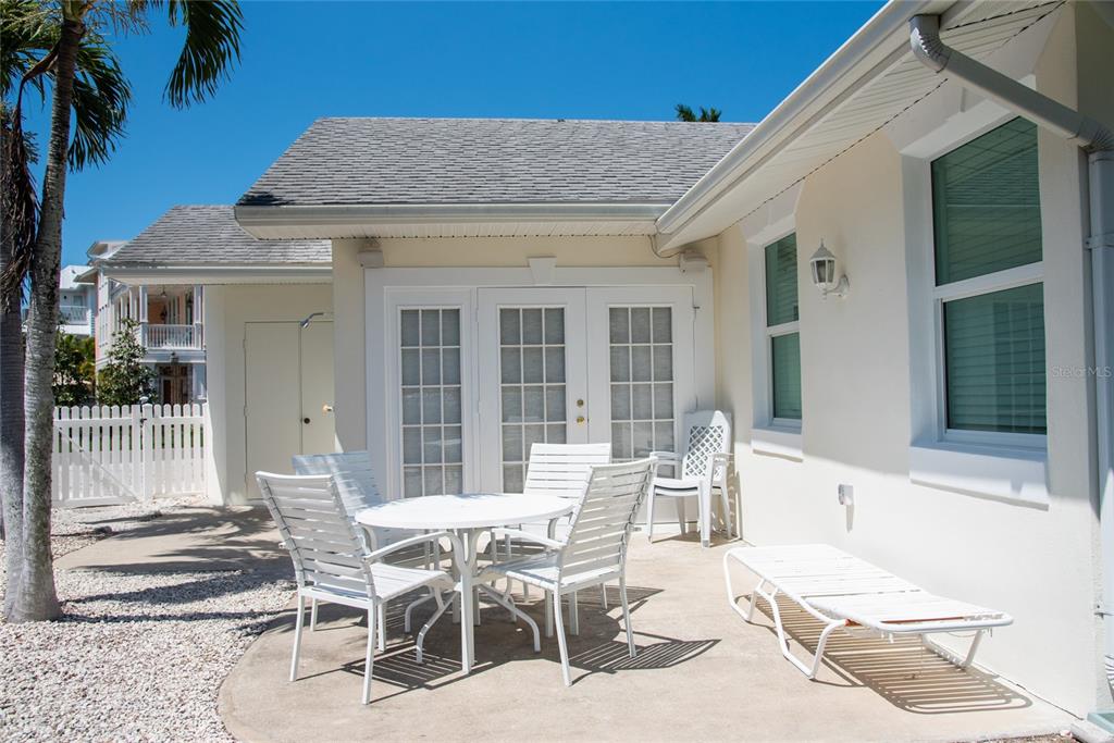 A single-story house exterior with a light-colored stucco facade, two windows, and a sun-shaped wall decoration — 117 79TH STREET, HOLMES BEACH, FL