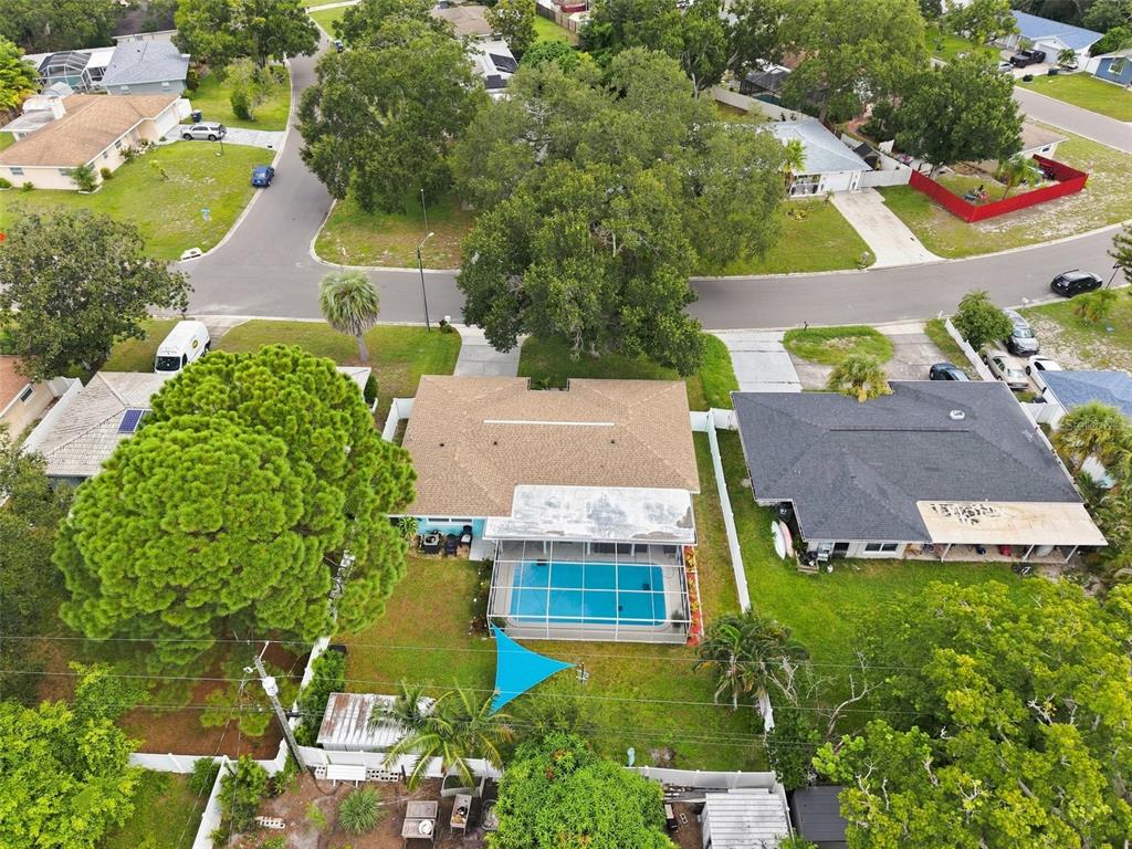An aerial view of a suburban house featuring a backyard swimming pool with a screen enclosure — 1359 HOWARD STREET, CLEARWATER, FL