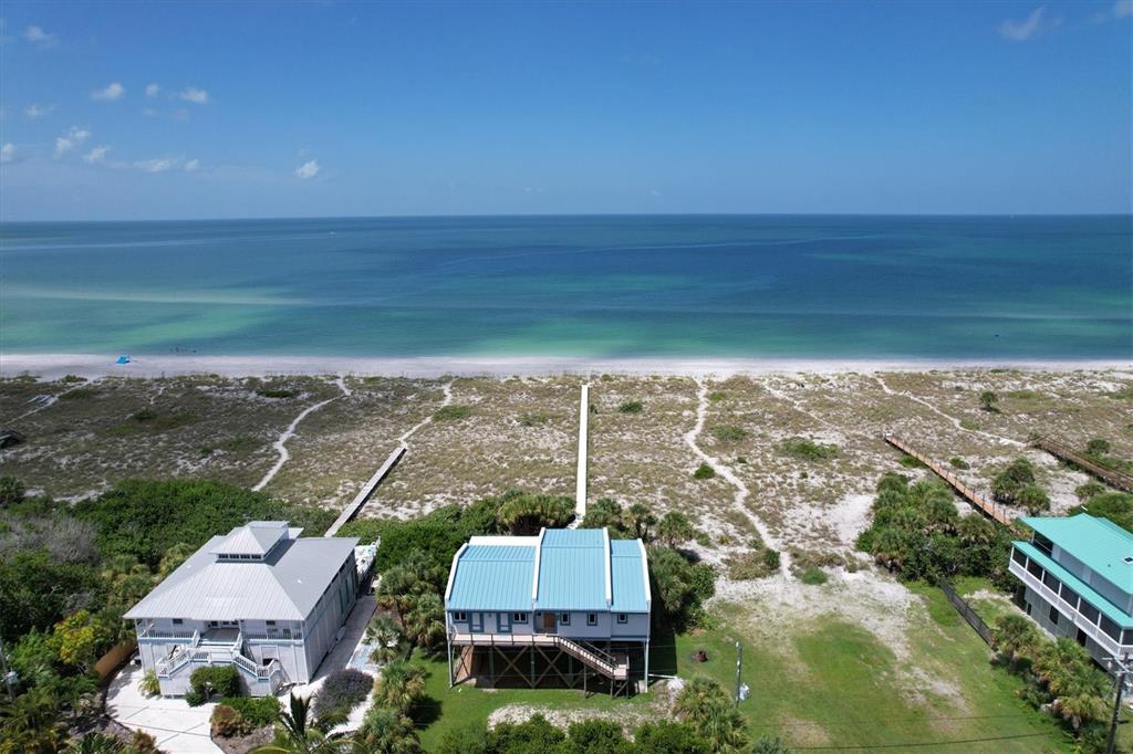 An aerial view of two beachfront houses with metal roofs and private boardwalks to the ocean — 9478 ALBORADO ROAD, PLACIDA, FL