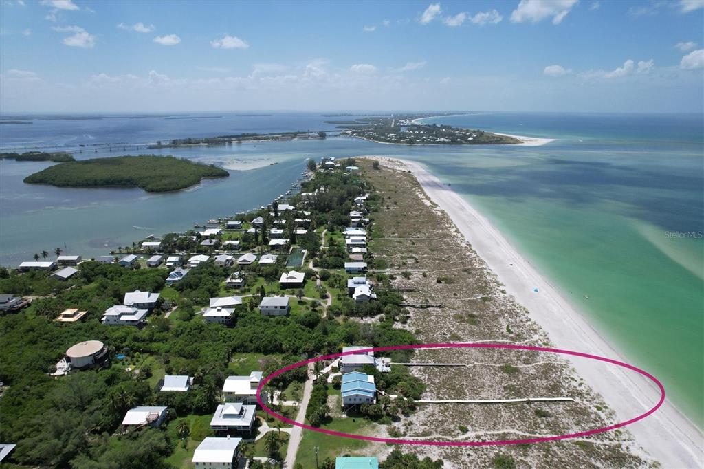 An aerial view shows a coastal house with a private boardwalk leading to the beach — 9478 ALBORADO ROAD, PLACIDA, FL