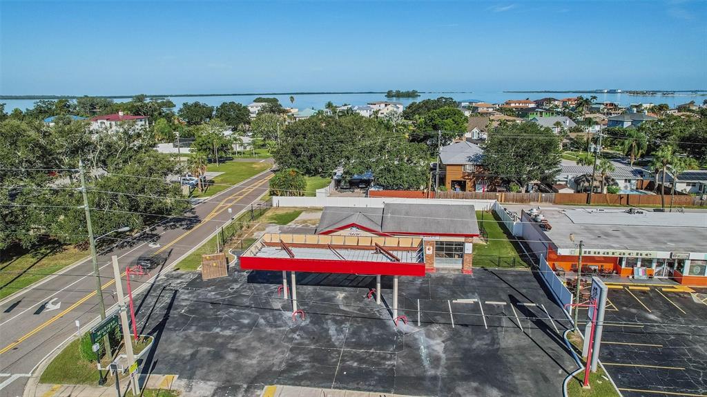 An aerial view shows a commercial building with a red canopy and a parking lot — 2000 BAYSHORE BOULEVARD, DUNEDIN, FL