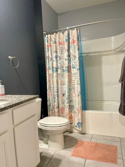 A bathroom features a white vanity, a toilet, and a shower with a patterned curtain — 1810 EAGLE HAMMOCK BOULEVARD, EAGLE LAKE, FL