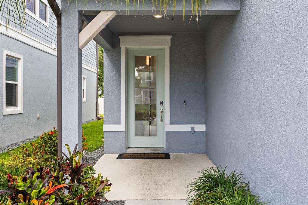 A light blue front door with a glass panel sits under a covered porch — 2993 PIER POINTE LANE, CLEARWATER, FL
