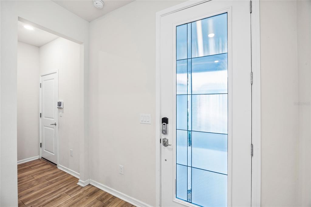 An entryway features wood-look flooring, a white door with a glass panel, and a closet — 2993 PIER POINTE LANE, CLEARWATER, FL