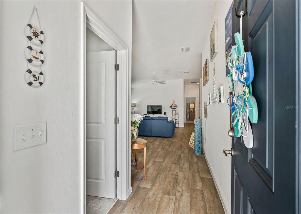 A view from an entryway looking into a living room with wood-look flooring — 3250 SHERFINSKI AVENUE, THE VILLAGES, FL
