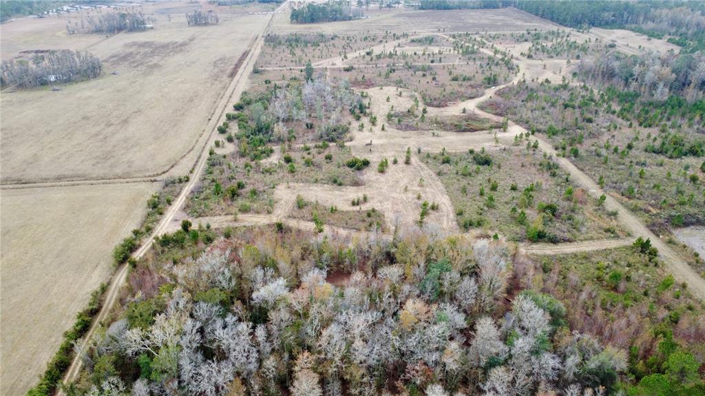 An aerial view shows a large, undeveloped plot of land outlined in red — TBD CR 235, BROOKER, FL