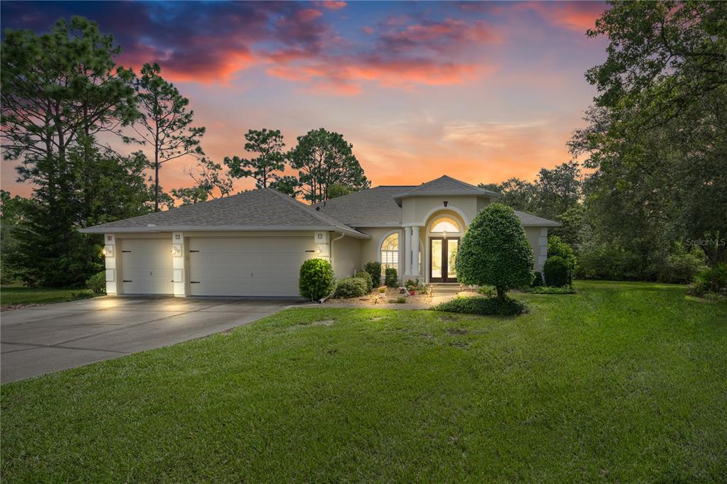A single-story house with a two-car garage and a front entrance under a covered porch — 1 COLUBRINA COURT, HOMOSASSA, FL
