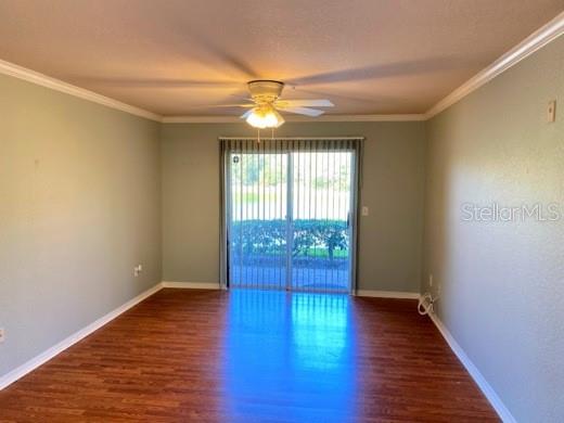 An empty room with light green walls, wood-look flooring, a ceiling fan, and sliding glass doors — 4201 WOODSTORKS WALK WAY UNIT 3111, LUTZ, FL
