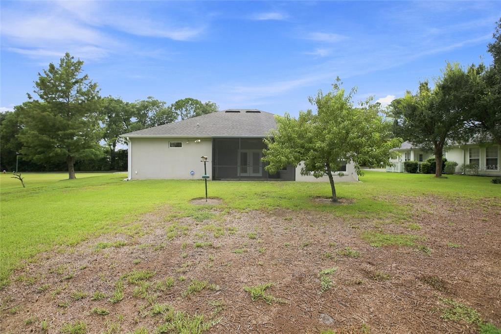 A covered entryway features a double door with glass inserts and a metal bench — 555 DOWLING CIRCLE, LADY LAKE, FL