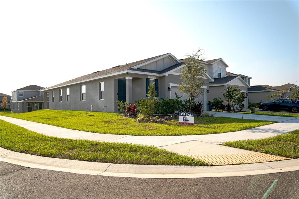 A gray, single-story suburban house with a garage and a for sale sign — 5503 BLUEBONNET PLACE, HAINES CITY, FL