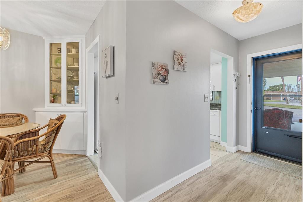 A dining area with a built-in hutch leads to a kitchen and a front entryway — 4803 PARK ACRES DRIVE, BRADENTON, FL