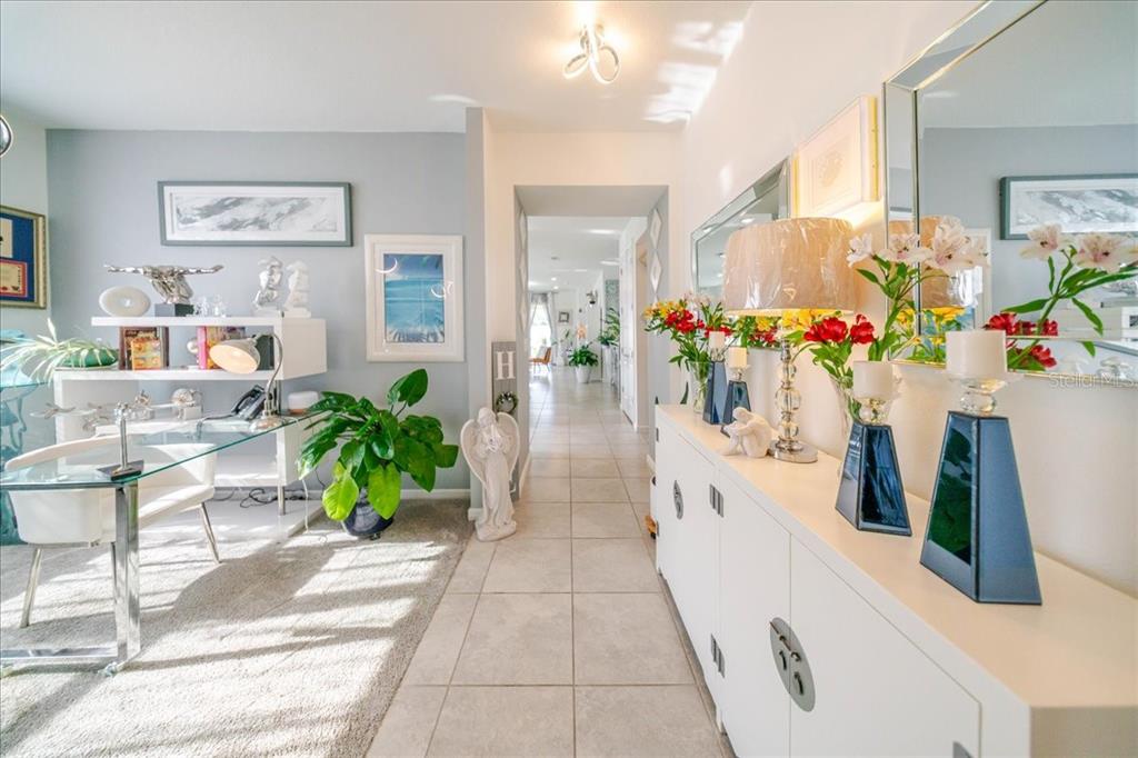 A bright entryway features a glass desk on the left and a white console table — 1833 SPRING SHOWER CIRCLE, KISSIMMEE, FL