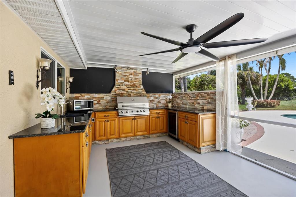 A screened-in patio features white furniture, a round coffee table, and a ceiling fan — 1819 SE ELROSE STREET, PORT ST LUCIE, FL