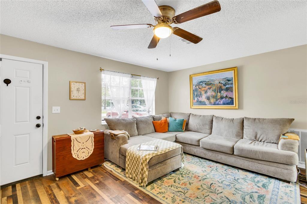 A kitchen features light wood cabinets, white appliances, a dining table, and a stainless refrigerator — 1733 LARKIN ROAD, SPRING HILL, FL