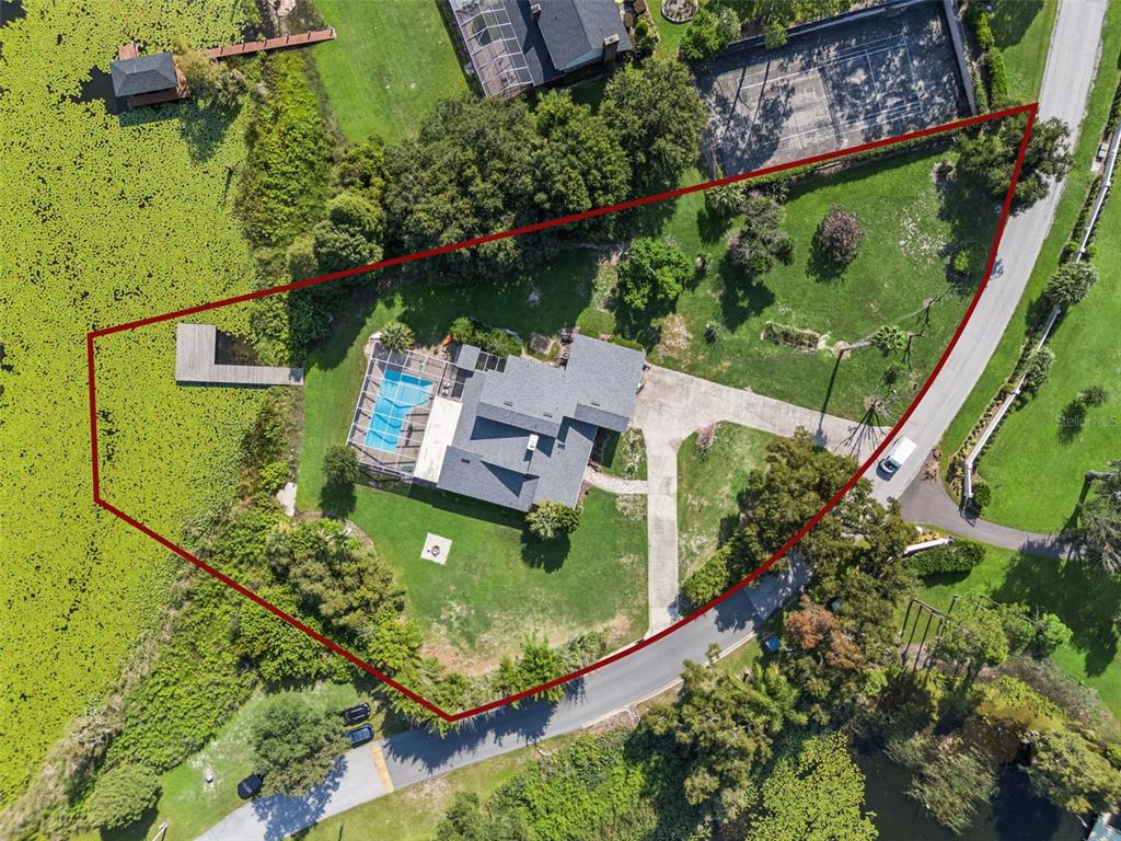 An aerial view shows two houses with screened pools situated on a peninsula between lakes — 25 LAKEWOOD CAUSEWAY, WINTER HAVEN, FL