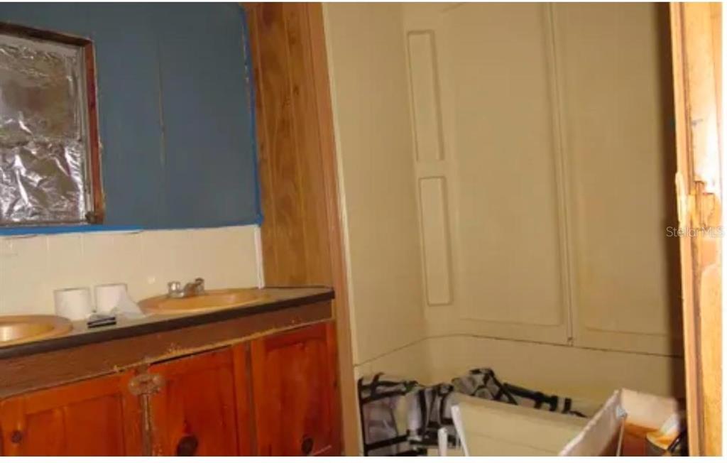 A bathroom features a double vanity with wood cabinets and a beige shower stall — 10130 208TH PATH, O'BRIEN, FL