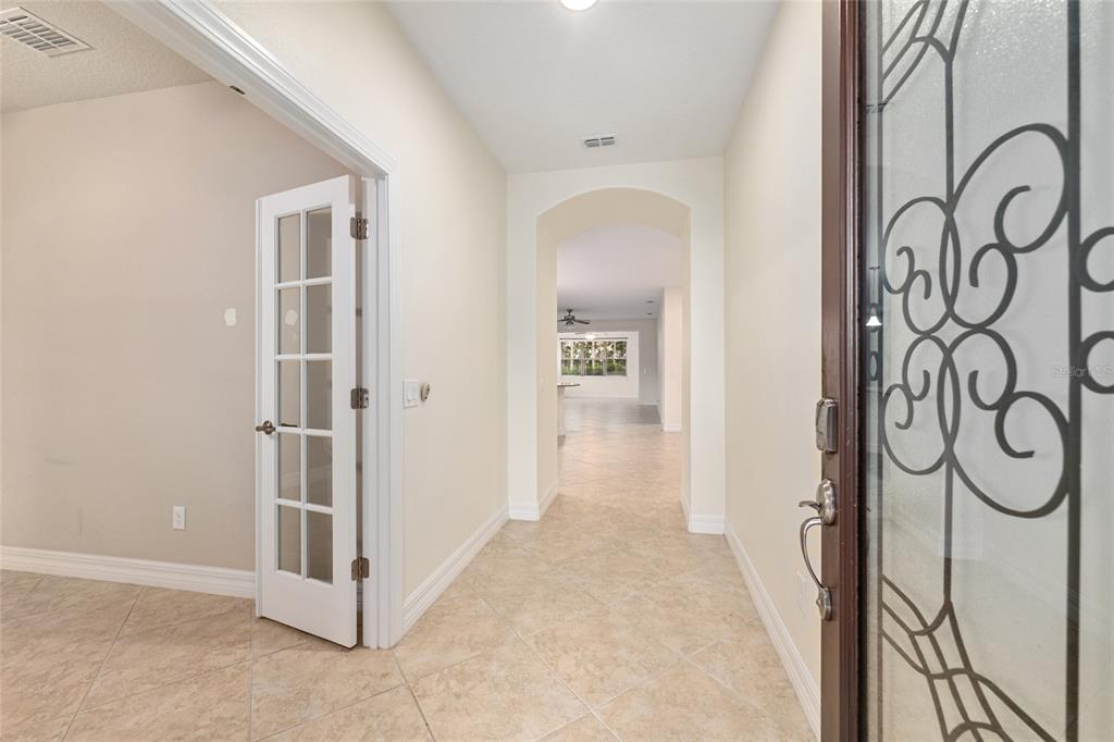 A tiled entryway features a glass-paneled front door and a French door leading to a room — 9221 SW 70TH LOOP, OCALA, FL