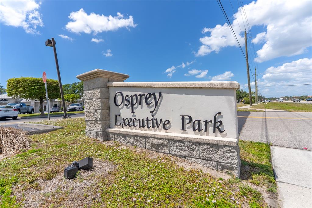 A stone monument sign for Osprey Executive Park stands near a road under a blue sky — 436 S TAMIAMI TRAIL UNIT C4, OSPREY, FL