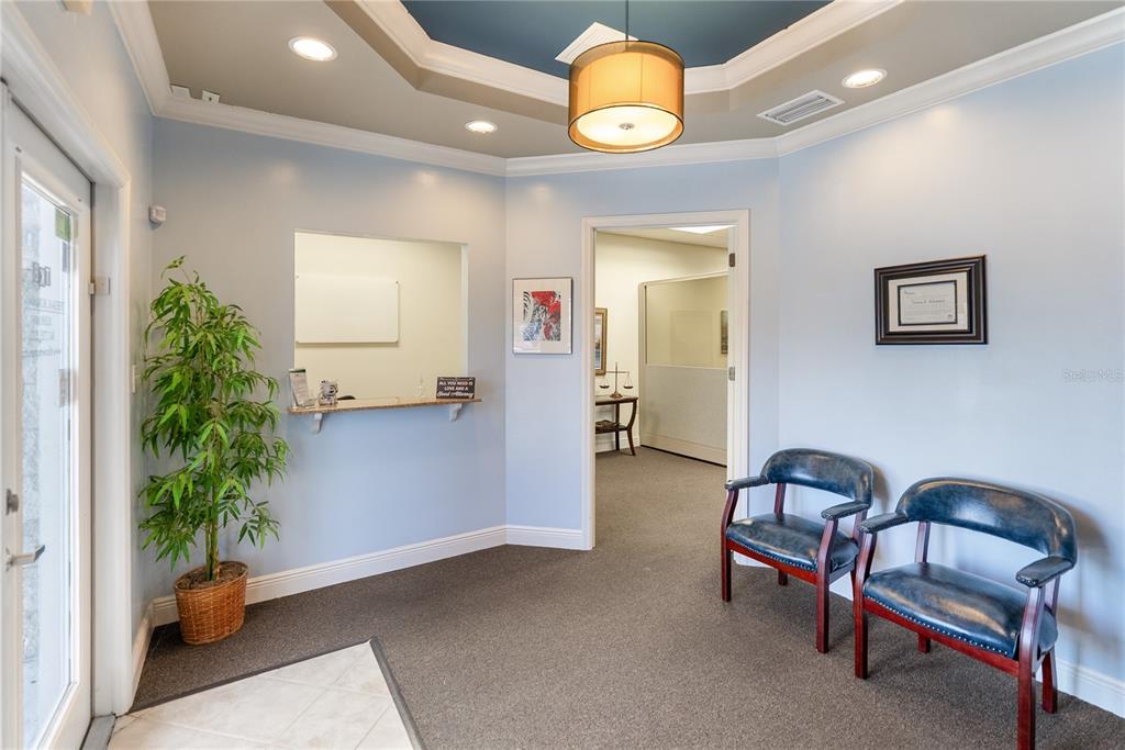 A waiting area with light blue walls, two leather chairs, and a reception window — 436 S TAMIAMI TRAIL UNIT C4, OSPREY, FL