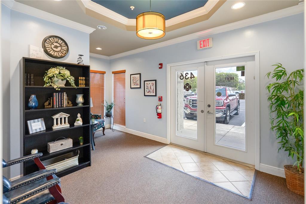 A lobby features a black bookshelf, a central light fixture, and glass double doors — 436 S TAMIAMI TRAIL UNIT C4, OSPREY, FL