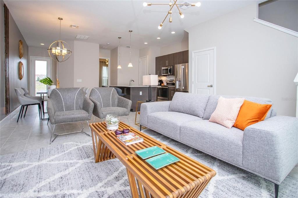 A living room with a gray sofa, two armchairs, and a wooden slatted coffee table — 168 VILLA DOMANI CIRCLE, DAVENPORT, FL