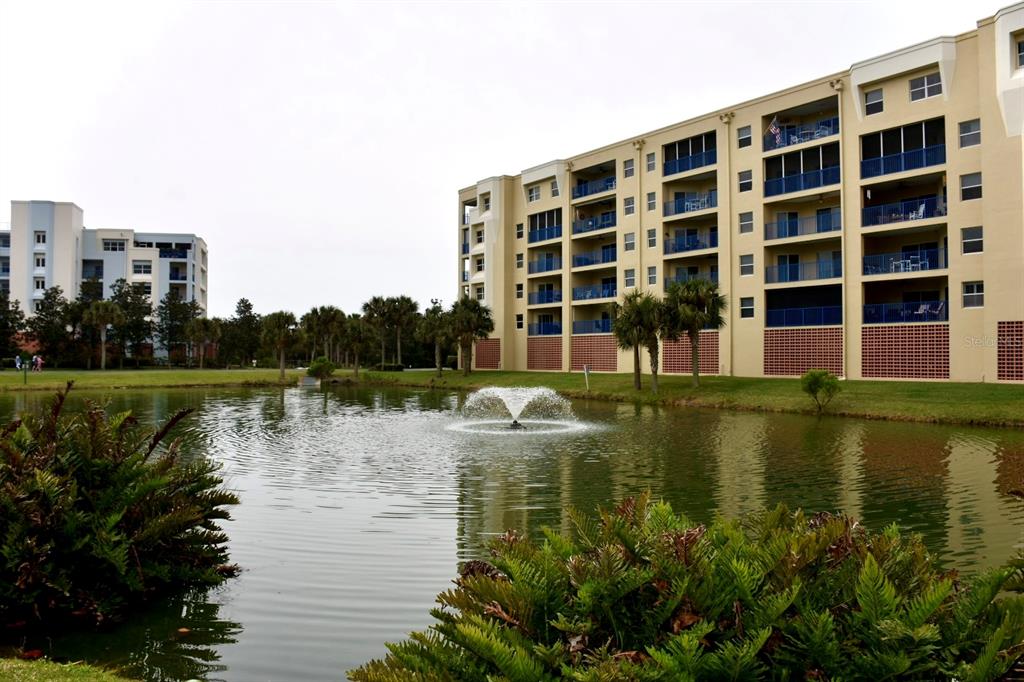 A pond with a fountain sits in front of two large, multi-story apartment buildings — 5300 S ATLANTIC AVENUE UNIT 8-302, NEW SMYRNA BEACH, FL