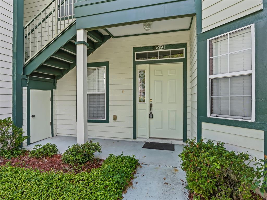 The exterior entrance of a residential unit features a light green door labeled 309 — 231 NE 28TH AVENUE UNIT 309, OCALA, FL