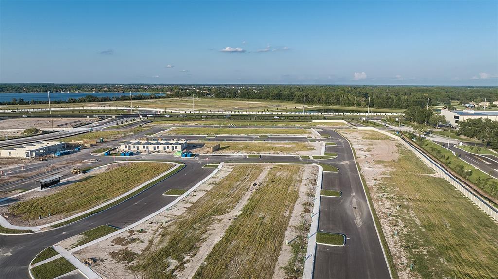 An aerial view shows a developing residential subdivision with paved roads and cleared building lots — 19341 LOCHSIDE LANE, MOUNT DORA, FL